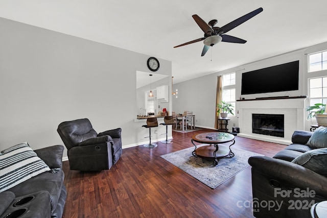 living room featuring dark wood-type flooring, a fireplace, and ceiling fan