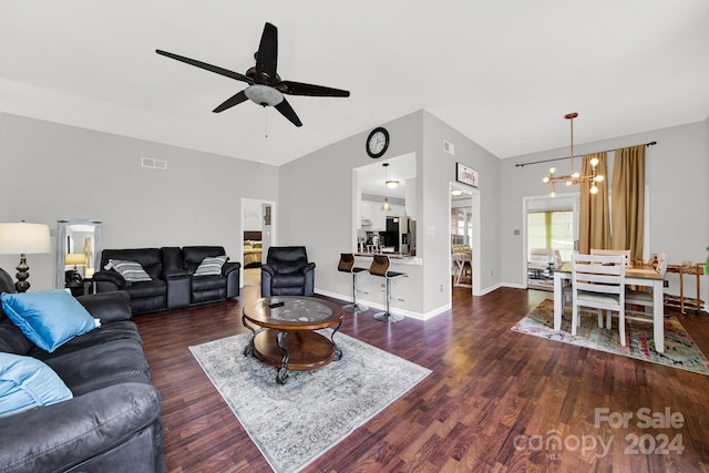 living room with ceiling fan with notable chandelier and dark wood-type flooring