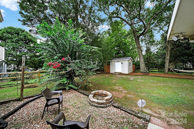 view of yard featuring a fire pit and a storage shed