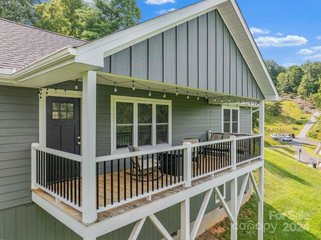 view of side of home with a deck and a lawn