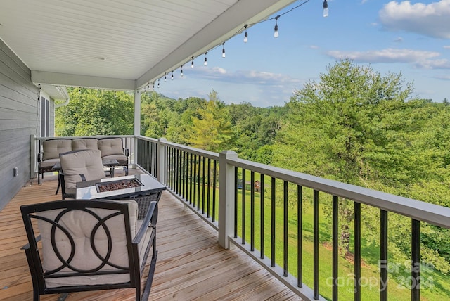 deck with an outdoor living space with a fire pit