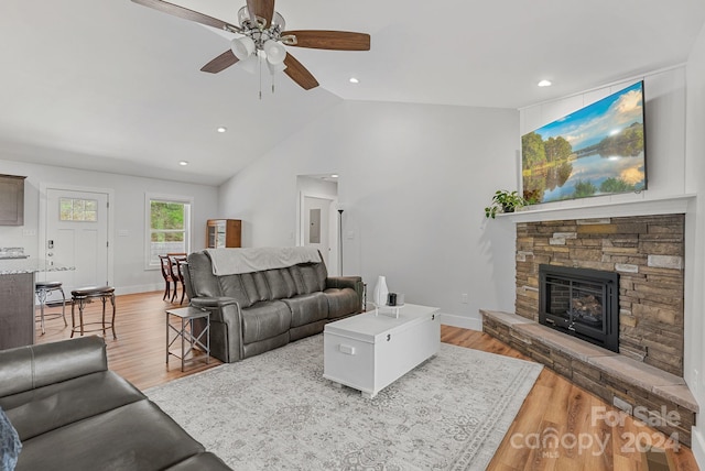 living room with a fireplace, ceiling fan, wood-type flooring, and lofted ceiling