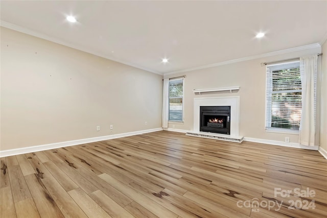 unfurnished living room with ornamental molding and light hardwood / wood-style floors