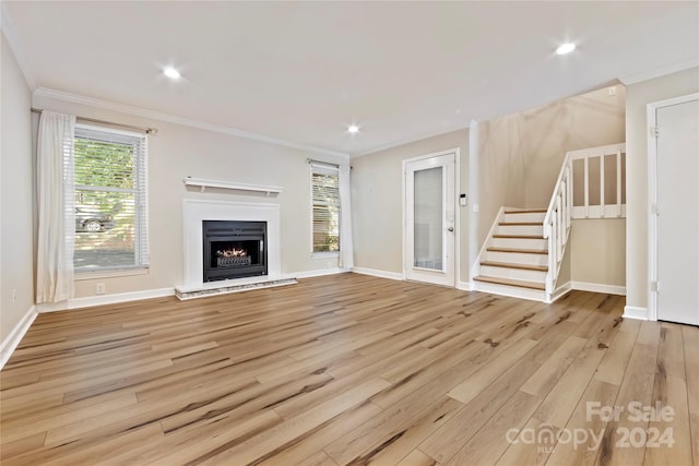 unfurnished living room with light wood-type flooring and ornamental molding