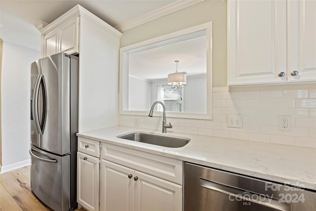 kitchen featuring decorative backsplash, stainless steel appliances, light hardwood / wood-style floors, and sink