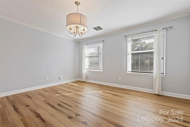 unfurnished room featuring light hardwood / wood-style floors, a chandelier, and plenty of natural light