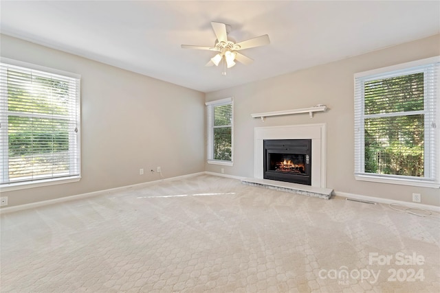 unfurnished living room with light colored carpet and plenty of natural light