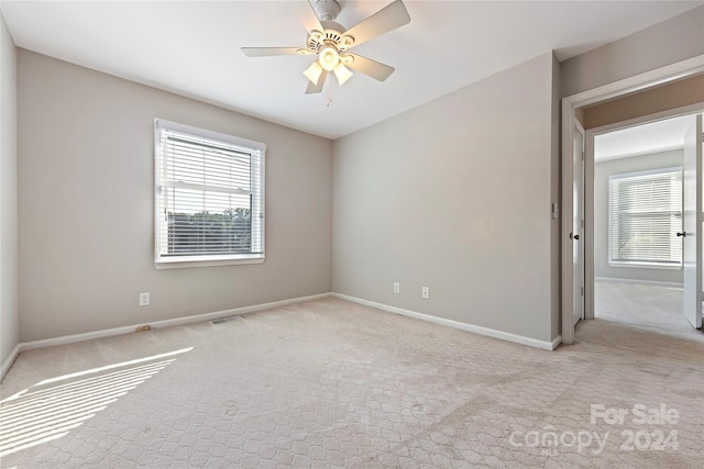 unfurnished room featuring ceiling fan and light colored carpet