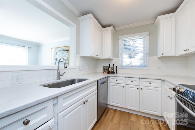 kitchen with stainless steel appliances, white cabinets, crown molding, and a sink