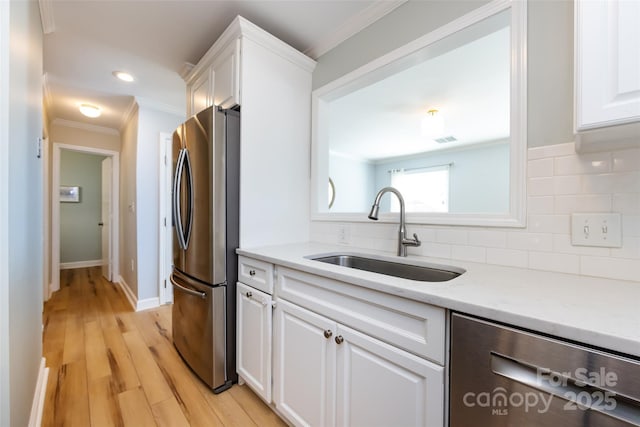 kitchen featuring crown molding, appliances with stainless steel finishes, decorative backsplash, and a sink