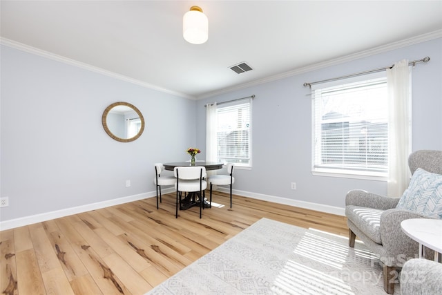 dining room with ornamental molding, wood finished floors, and visible vents