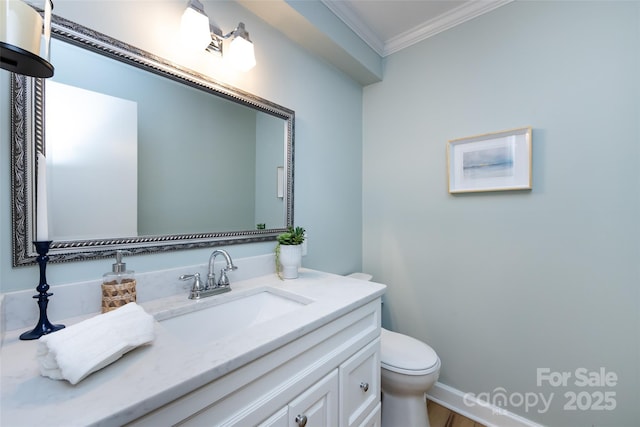 bathroom with ornamental molding, vanity, and toilet