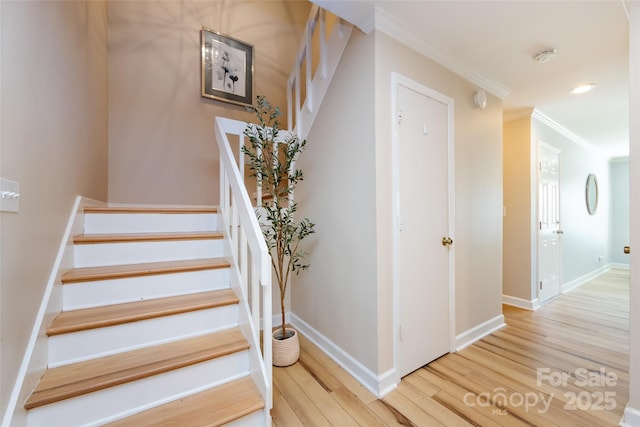 staircase featuring ornamental molding, recessed lighting, wood finished floors, and baseboards