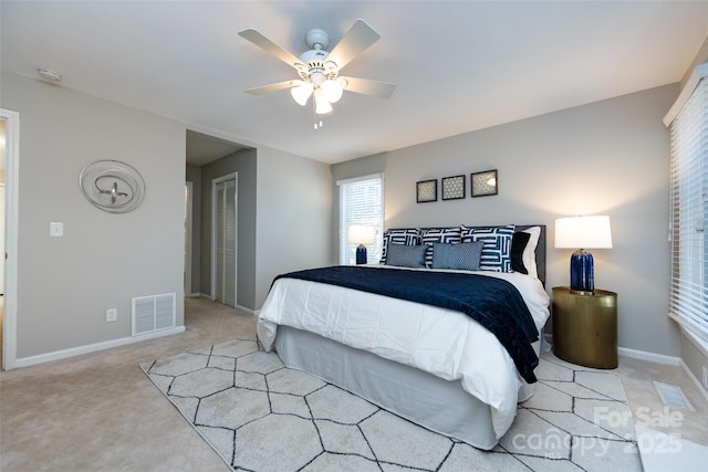 bedroom with baseboards, visible vents, a ceiling fan, carpet flooring, and a closet