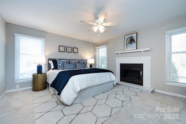 bedroom featuring baseboards, visible vents, carpet flooring, and multiple windows