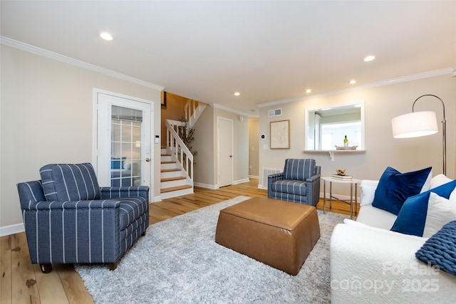 living room featuring stairs, ornamental molding, and wood finished floors