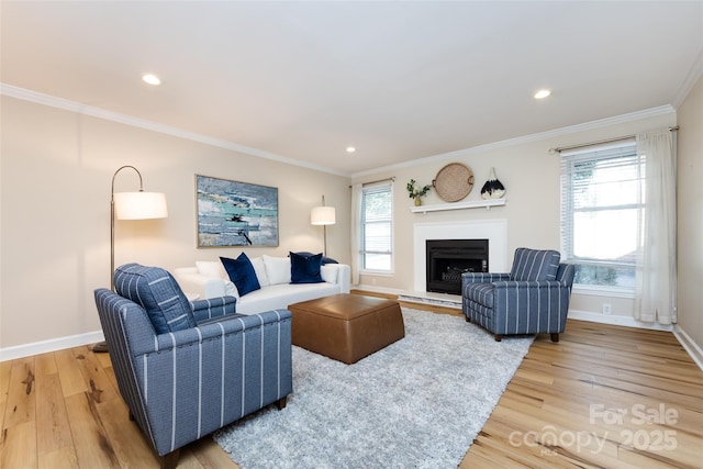 living area featuring light wood-style floors, a wealth of natural light, and crown molding