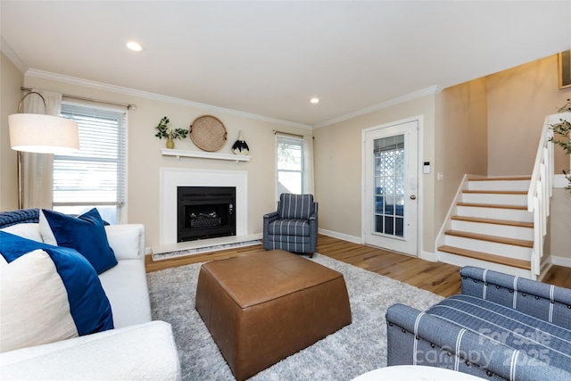 living room featuring ornamental molding, wood finished floors, baseboards, and stairs