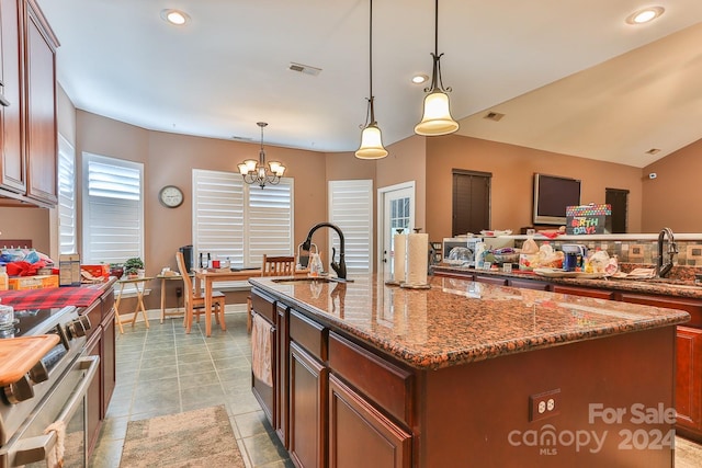 kitchen with stainless steel range, a center island with sink, sink, and light tile patterned flooring