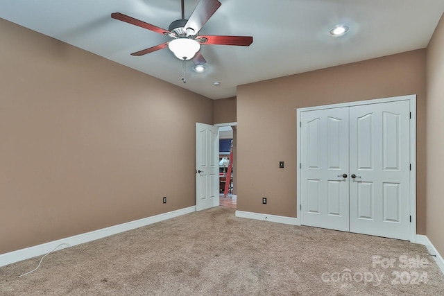 unfurnished bedroom featuring ceiling fan, a closet, and carpet