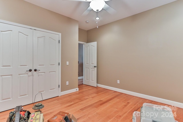 bedroom featuring ceiling fan, light wood-type flooring, and a closet