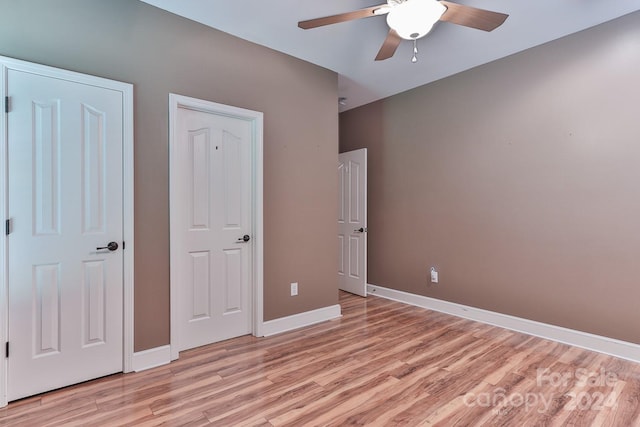 unfurnished bedroom with ceiling fan and light wood-type flooring