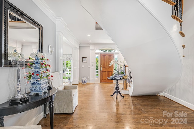 foyer entrance featuring hardwood / wood-style floors and crown molding