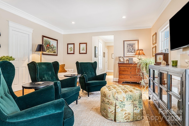 living area with ornamental molding and hardwood / wood-style flooring