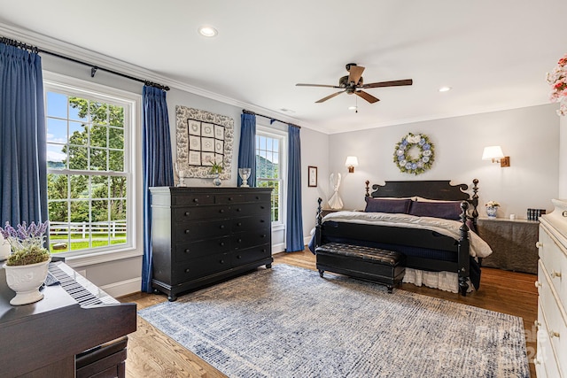 bedroom featuring ceiling fan, light hardwood / wood-style flooring, and multiple windows