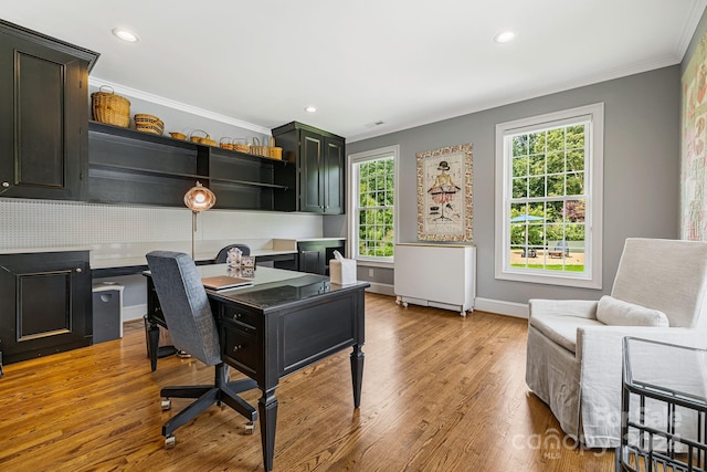 office space featuring light hardwood / wood-style flooring, ornamental molding, and built in desk