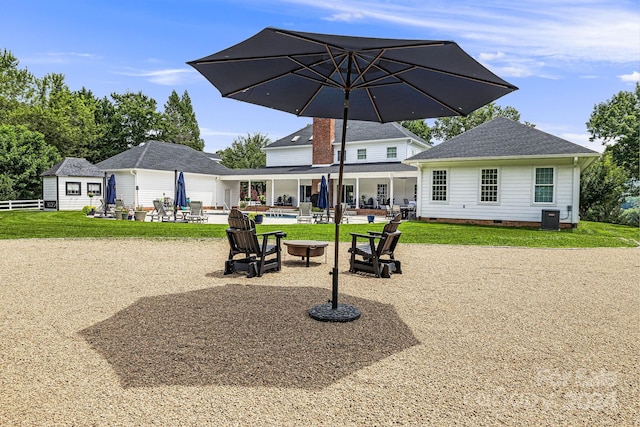 exterior space featuring a lawn, an outdoor structure, cooling unit, and a patio area