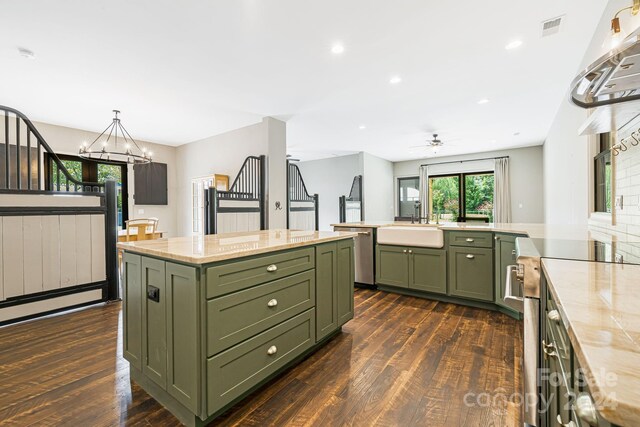 kitchen featuring dark hardwood / wood-style floors, sink, stainless steel dishwasher, range, and a center island