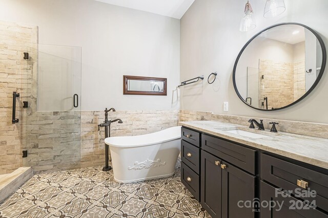 bathroom featuring shower with separate bathtub, vanity, and tile patterned flooring