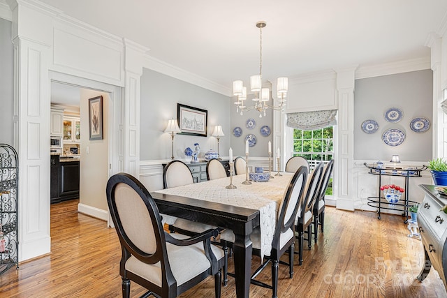56 Fair Oaks Est, Fletcher, NC 28732 - dining room with light wood-style flooring, a wainscoted wall, crown molding, a chandelier, and a decorative wall