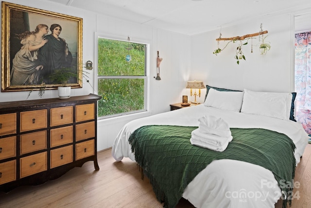 bedroom featuring multiple windows and light hardwood / wood-style flooring