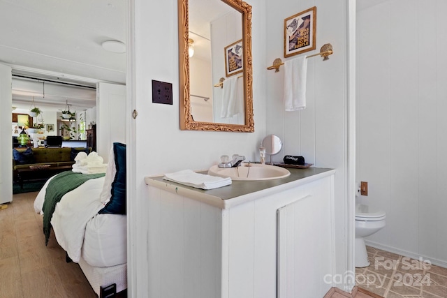 bathroom with vanity, toilet, and hardwood / wood-style floors