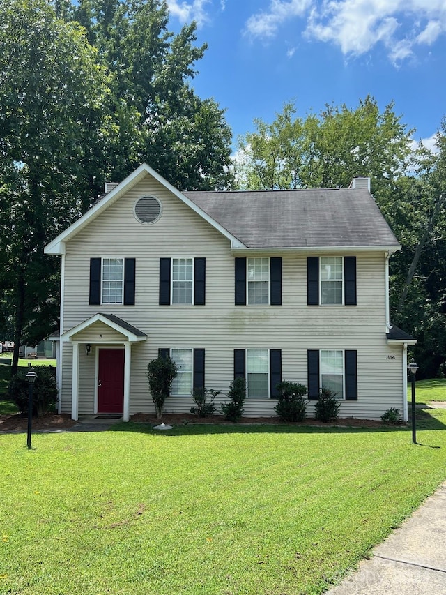 colonial home featuring a front lawn