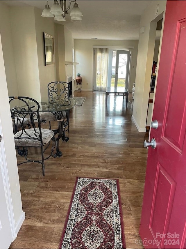 corridor featuring a notable chandelier, dark hardwood / wood-style flooring, and french doors