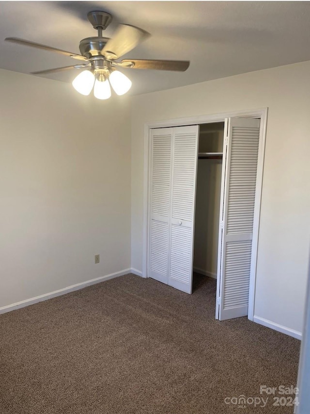 unfurnished bedroom with a closet, ceiling fan, and dark colored carpet