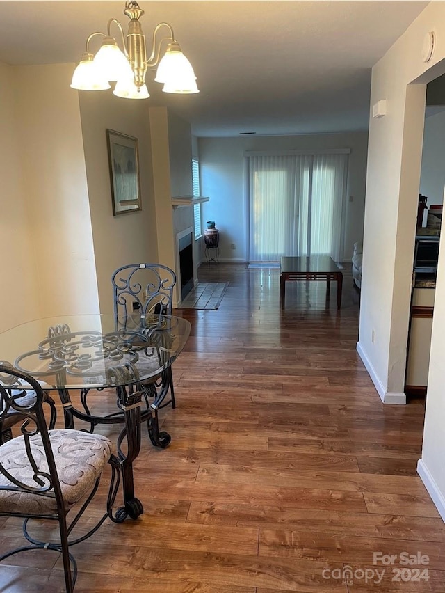 dining space with dark hardwood / wood-style floors and a notable chandelier