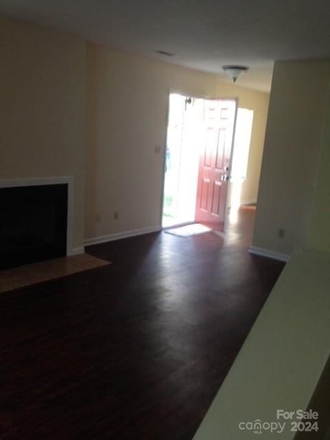 unfurnished living room with dark hardwood / wood-style floors