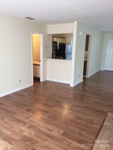 unfurnished living room with dark wood-type flooring