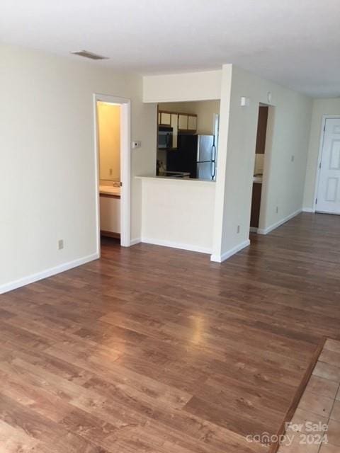814 Selwyn Oaks Ct Unit 9/A & B, Charlotte, NC 28209 - unfurnished living room featuring baseboards, visible vents, and wood finished floors