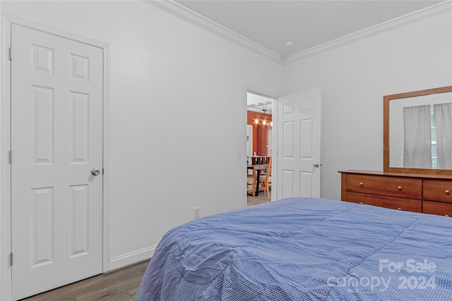 bedroom with wood-type flooring and ornamental molding