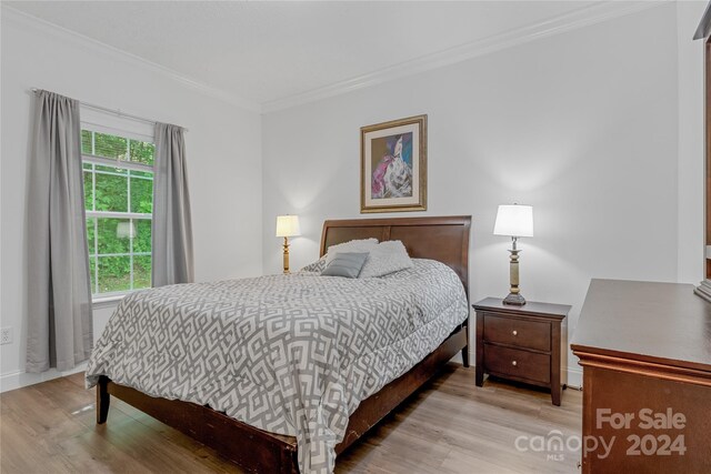 bedroom featuring crown molding and light hardwood / wood-style floors