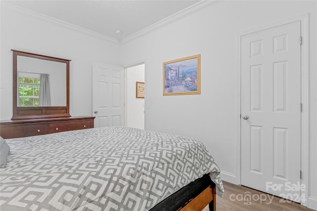 bedroom featuring hardwood / wood-style floors and ornamental molding