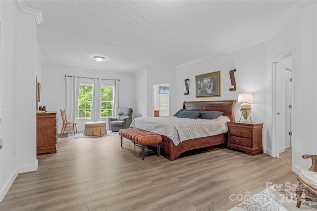 bedroom with a textured ceiling, light hardwood / wood-style floors, and crown molding