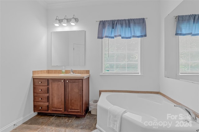 bathroom with tile patterned floors, a washtub, vanity, and a wealth of natural light