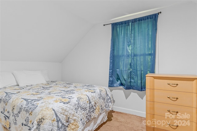 bedroom with vaulted ceiling and light colored carpet