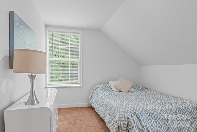 bedroom with lofted ceiling and light carpet